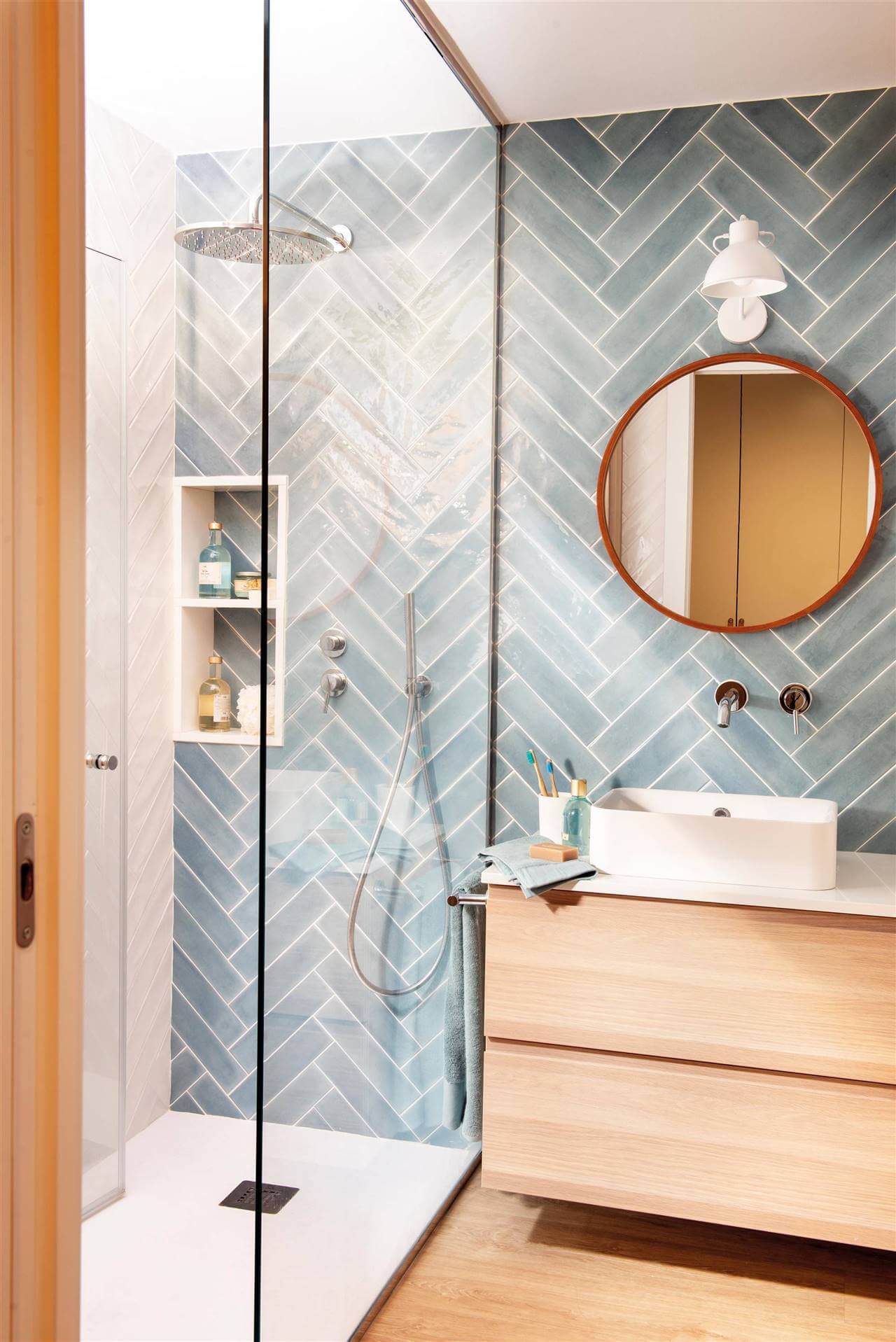 bano con azulejos de pared en gris formando espiga - ¿Qué baldosas funcionan mejor en baños pequeños?