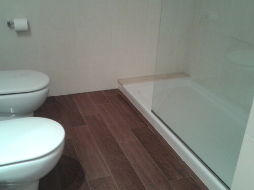 El baño principal, con cerámica de imitación parquet en wengué