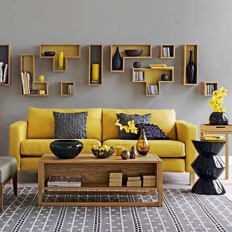 Un sofá amarillo en un salón decorado en gris.
